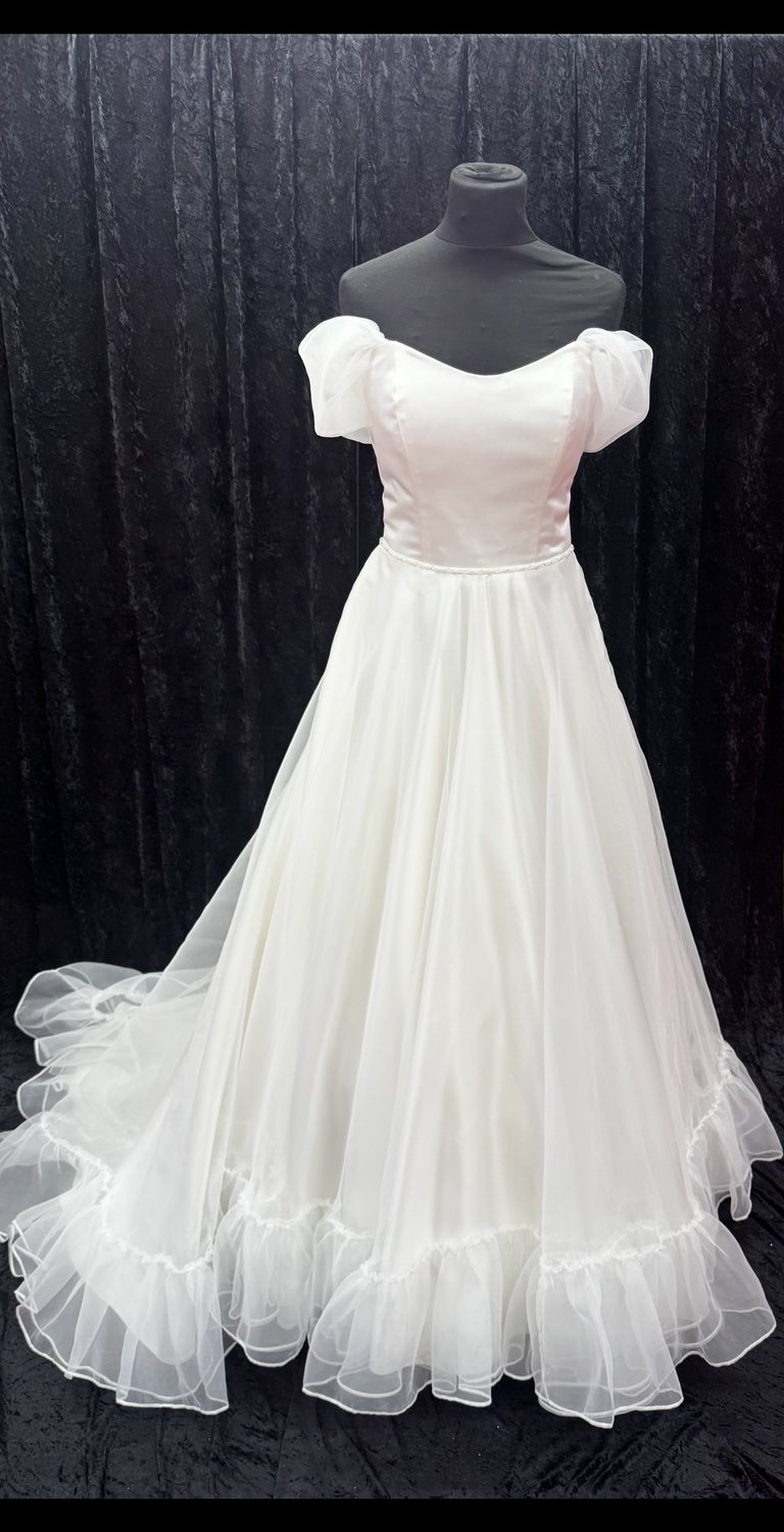 Off-the-shoulder satin wedding gown with train at Brides of Bond Street, Leicester